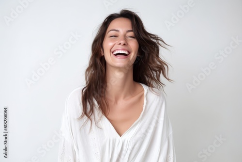 Portrait of a happy young woman laughing isolated on a white background