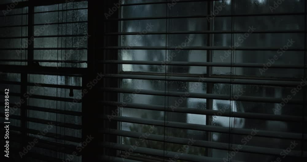 Rainy street through blindes from inside house Rainy street through blindes from inside house