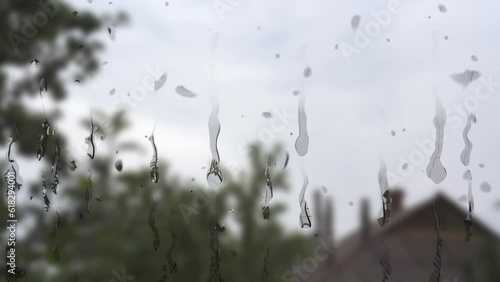 animation of raindrops on the window on the background of the house