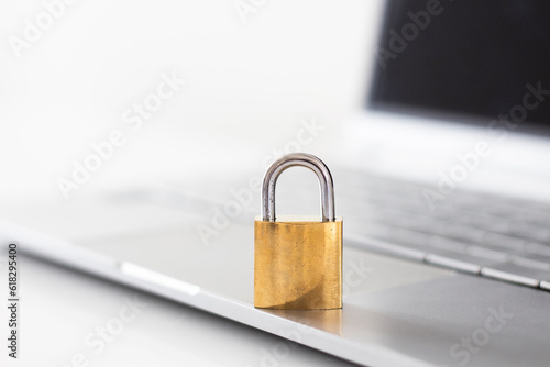 Gold locked padlock on laptop. Computer security concept. Close up