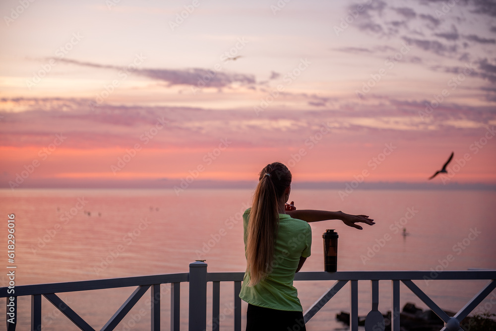 Fototapeta premium Young woman does warm-up in morning before running training. Healthy fitness