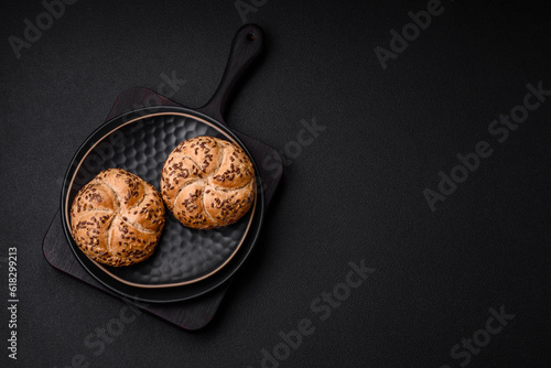 Delicious freshly baked crispy bun or kaiser roll with sesame seeds photo