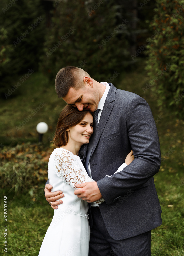 the young bride gently clings to the groom's chest. wedding day in autumn time.amazingly beautiful couple of newlyweds. the young bride gently clings to the groom's chest. wedding day in autumn time.amazingly beautiful couple of newlyweds.