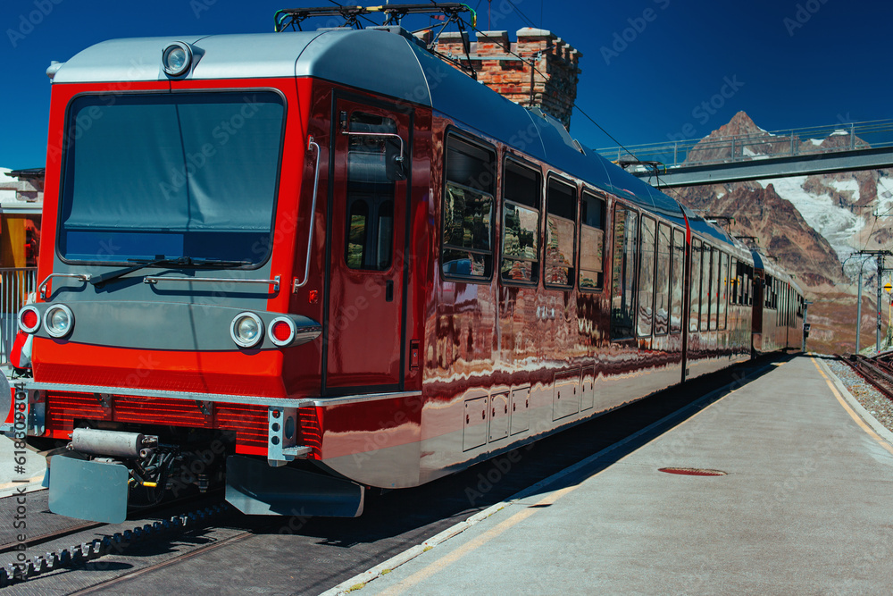 Alps high mountain train station with red train
