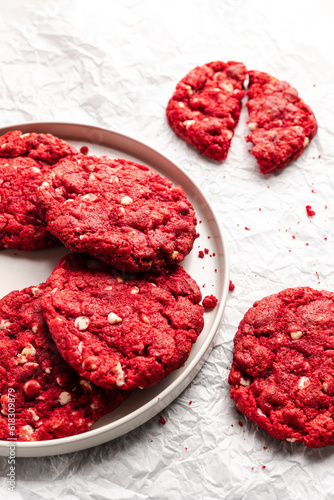 Red velvet cookies over a cookies rack with a glass of milk