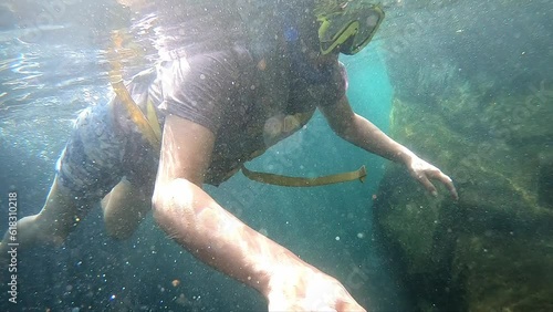 Mujer buseando en las islas galápagos con todo el equipo en un mar azul y con reflejos del agua sobre ella  photo