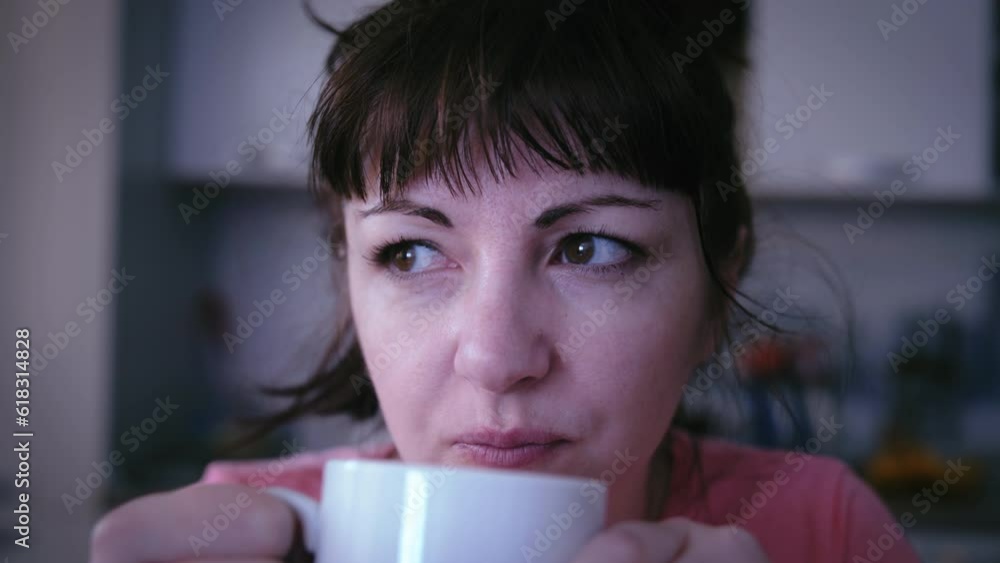 Woman Enjoying Morning Coffee at Home in the Kitchen, Gazing Out the Window Lost in Thought Woman Enjoying Morning Coffee at Home in the Kitchen, Gazing Out the Window Lost in Thought