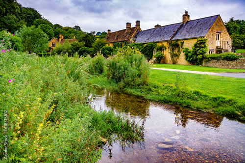 A small stream flows past country houses in rural England