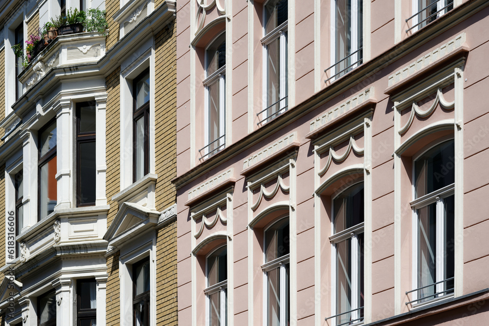 renovated facades of pastel colored and richly decorated residential houses from the end of the 19th century in cologne's eigelstein quarter