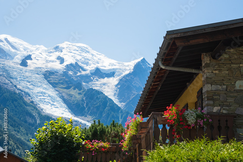 Chamonix-Mont-Blanc, France. Beautiful Alpine landscape with snow covered Mont Blanc mountain in summer and traditional chalet house at foreground. Haute-Savoie tourism.  Europe vacation destinations. photo