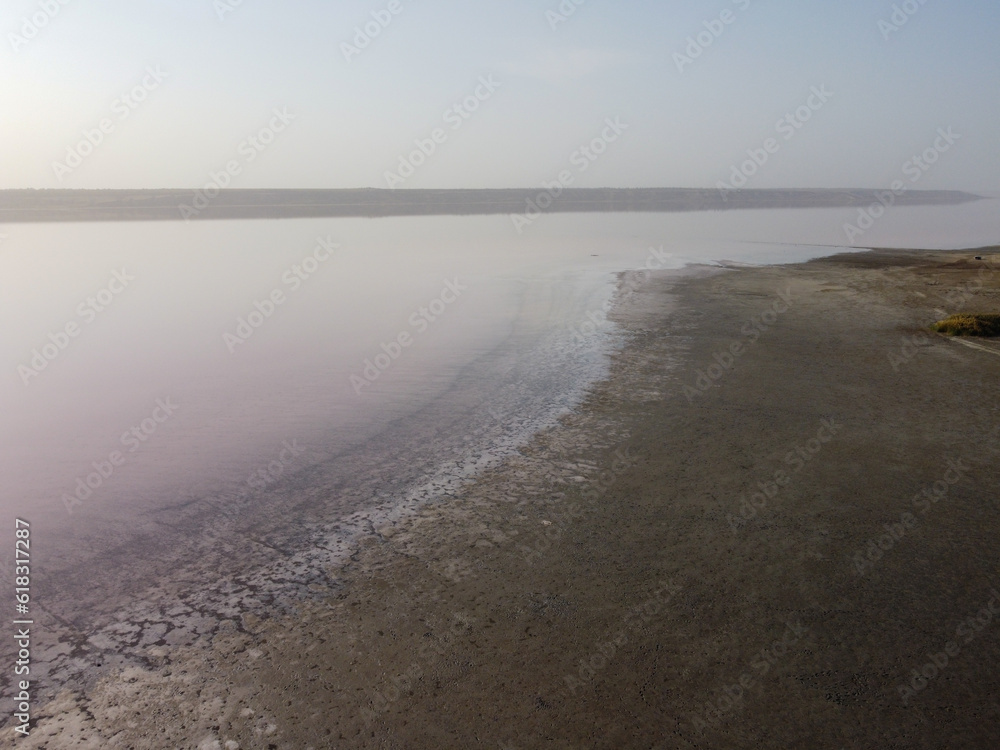 a serene lake with a muddy shore, surrounded by a tranquil atmosphere