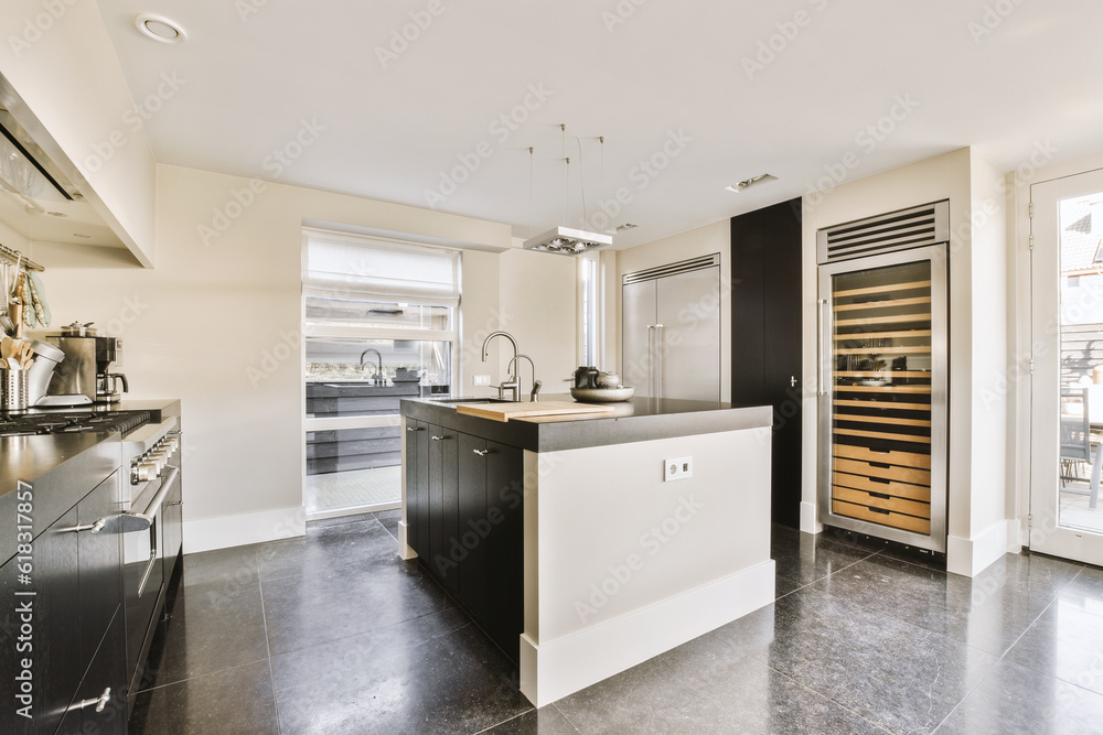 a modern kitchen with black and white appliances on the counters, along with an open door leading to another room a modern kitchen with black and white appliances on the counters, along with an open door leading to another room