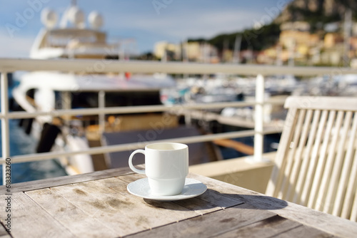 Cup of coffee on a wooden table on balcony hotel in Principality of Monaco.