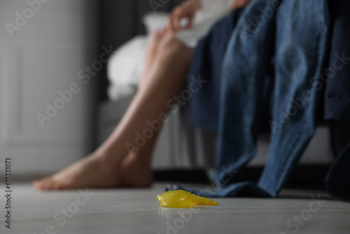 Unrolled condom on floor indoors, selective focus. Safe sex