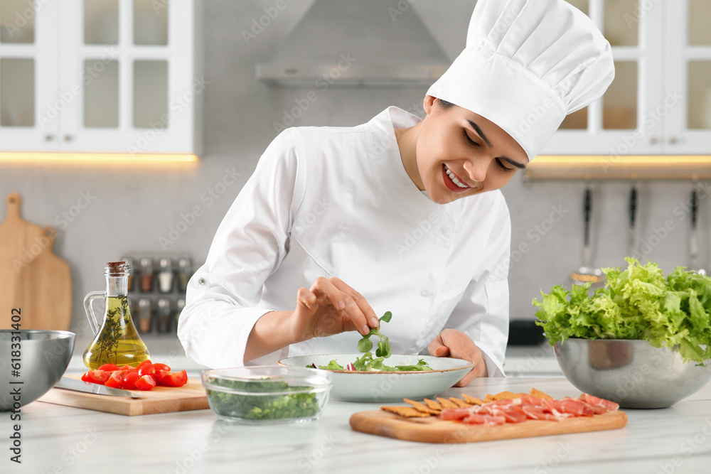 Professional chef cooking delicious salad at white marble table in kitchen