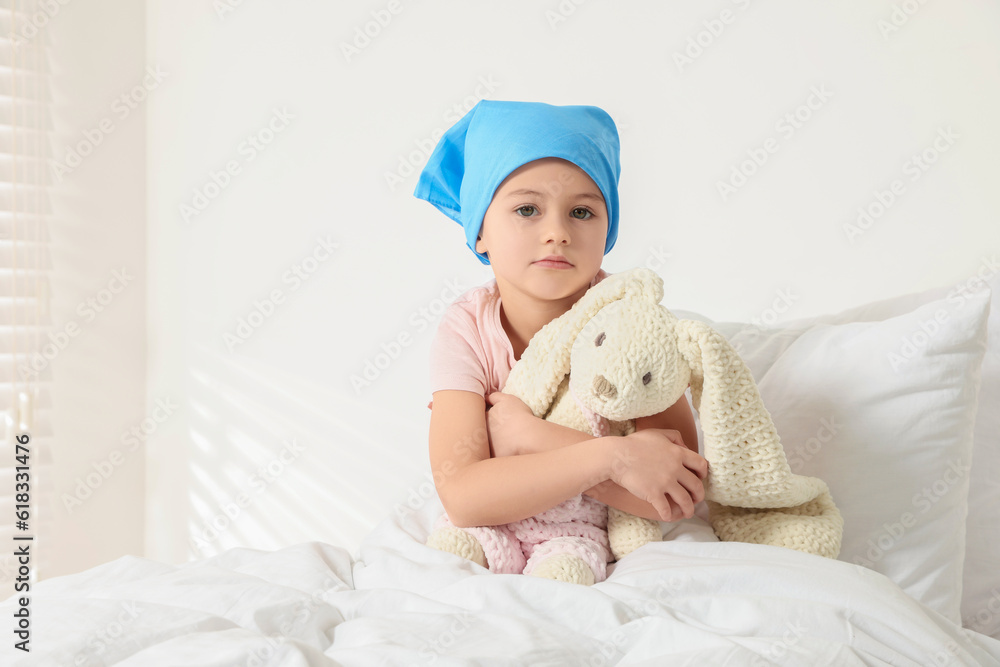 Childhood cancer. Girl with toy bunny in hospital Childhood cancer. Girl with toy bunny in hospital