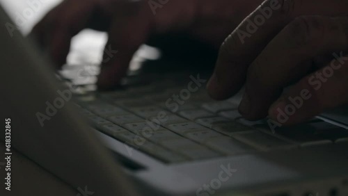close up of fingers typing on silver laptop keyboard selective focus