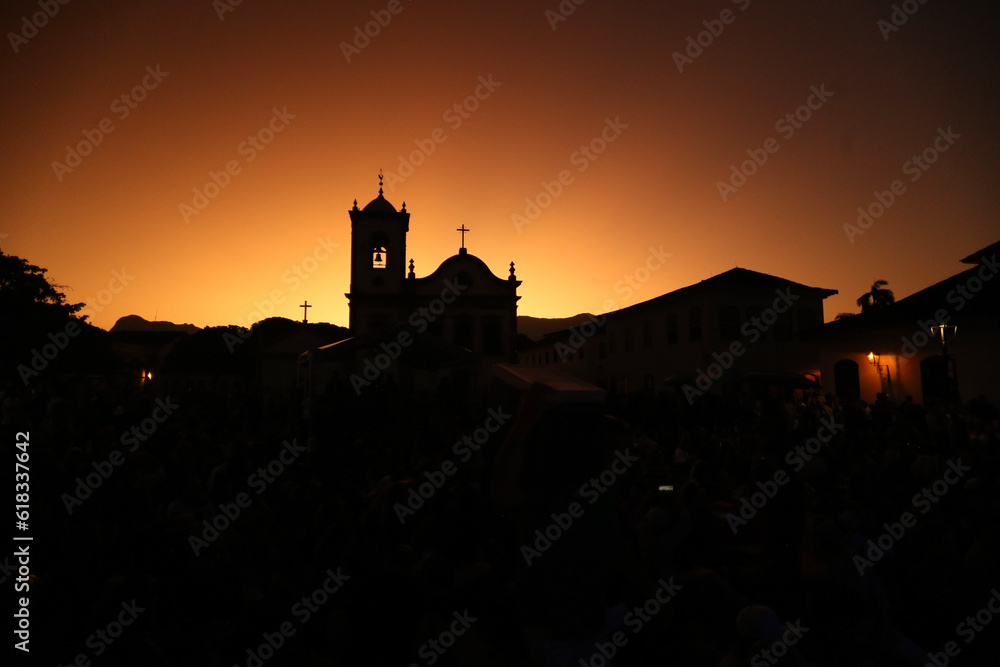 Silhueta da Igreja Santa Rita em Paraty, em um fim de tarde com céu alaranjado: a beleza divina iluminando a cidade