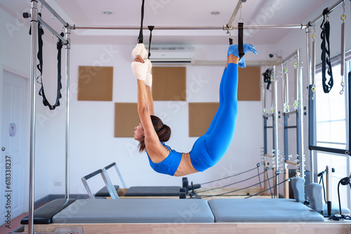 Fitness asian woman in sportswear training pilates on the reformer bed,Fitness concept,healthy and strong authentical body.