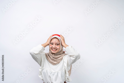 Shocked Asian muslim woman celebrate Indonesian independence day isolated on white background. Indonesian independence day on 17 august concept photo