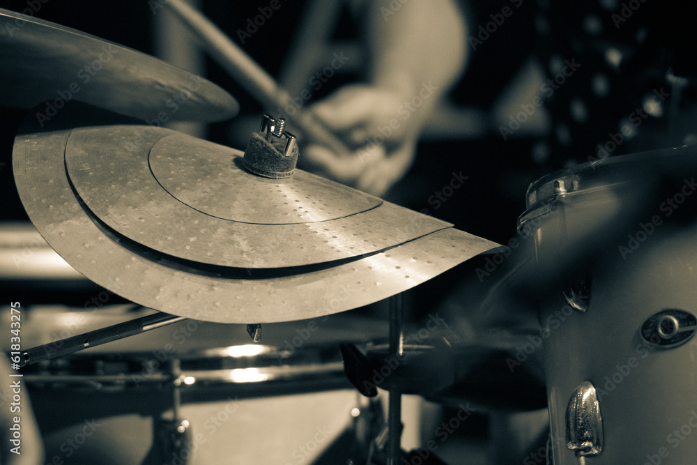 Jazz drummer with emphasis on a twisted cymbal, highlighting the drumstick in the drummer's hand. Selective focus. Jazz drummer with emphasis on a twisted cymbal, highlighting the drumstick in the drummer's hand. Selective focus.