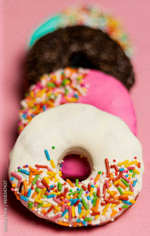 Closeup of colorful donuts in pink background 