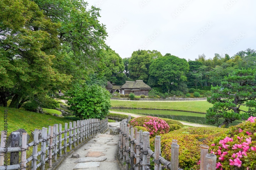 茅葺屋根の日本家屋がある日本庭園の春の情景