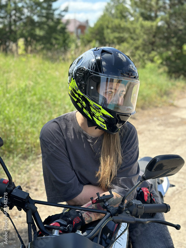 young woman in a helmet and gloves on a motorcycle