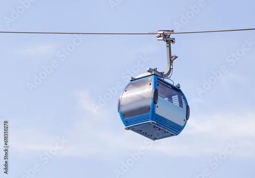 Empty blue cable car on a blue sky background.