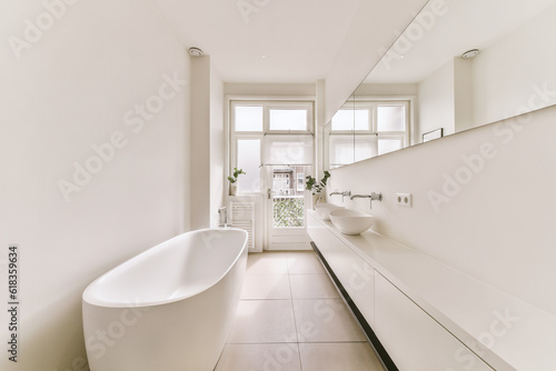 a bathroom with a bathtub and sink in the fore, taken from the side to the other part of the room