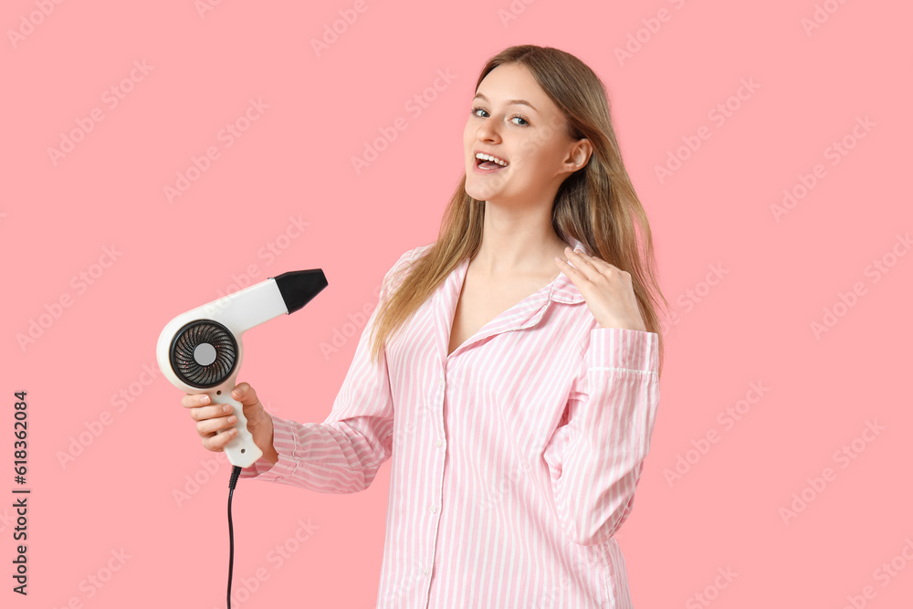 Beautiful young woman with hair dryer on pink background Beautiful young woman with hair dryer on pink background