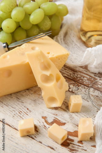 Tasty Swiss cheese on light wooden background