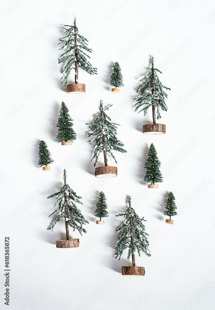 Miniature artificial Christmas trees layout. Decorative fir trees, winter holidays pattern.
