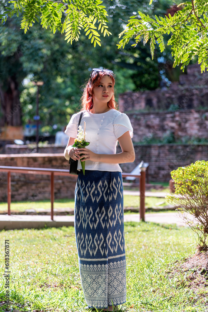 Young Asian women dressed in traditional costumes visit an old temple ...