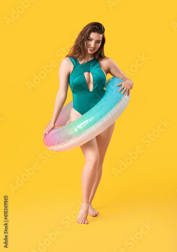 Young woman with swim ring on yellow background © Pixel-Shot