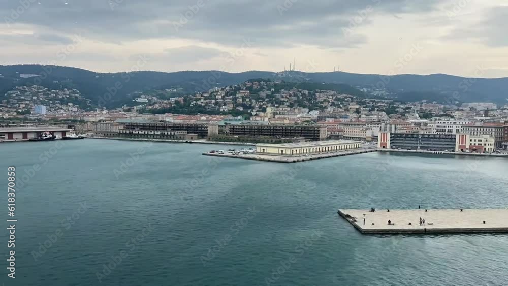 The city skyline of Trieste in Italy. Wind makes waves in the sea and there is a lot of traffic in the city. Time lapse The city skyline of Trieste in Italy. Wind makes waves in the sea and there is a lot of traffic in the city. Time lapse