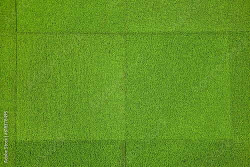 Top view artificial green grass for cover sports field or indoor gardening