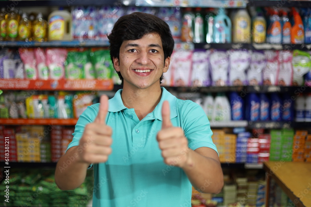 Happy Indian boy shopping in hypermarket buying grocery showing thumbs up Happy Indian boy shopping in hypermarket buying grocery showing thumbs up