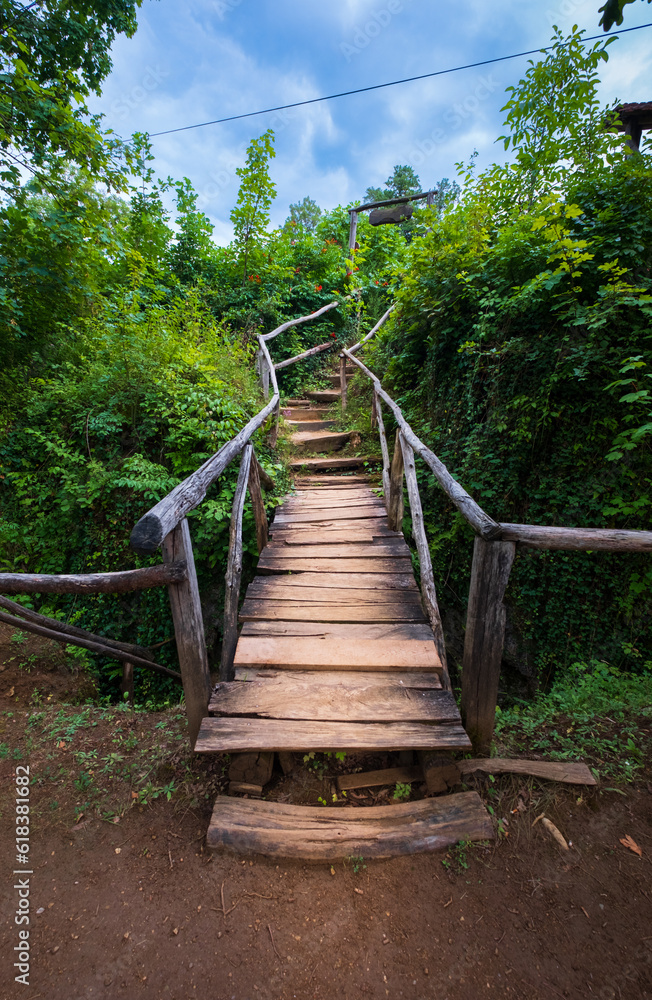 Wooden boardwalk in the green forest. Beautiful hiking trail or footpath across the river. Wooden path, way, track from planks in forest park. Plitvice Lakes, Croatia. Hiking Concept. Wooden boardwalk in the green forest. Beautiful hiking trail or footpath across the river. Wooden path, way, track from planks in forest park. Plitvice Lakes, Croatia. Hiking Concept.