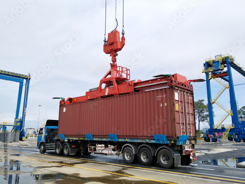 The spreader lifts the container onto the trailer. photo