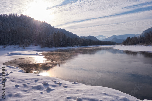 Altai river Biya in winter season. Banks of river are covered by ice and snow. photo