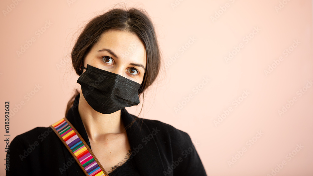 Woman with mask on looks towards camera Woman with mask on looks towards camera