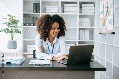 Successful African Businesswoman Analyzing Finance on Tablet and Laptop at modern Office Desk tax, report, accounting, statistics, and analytical research concept..