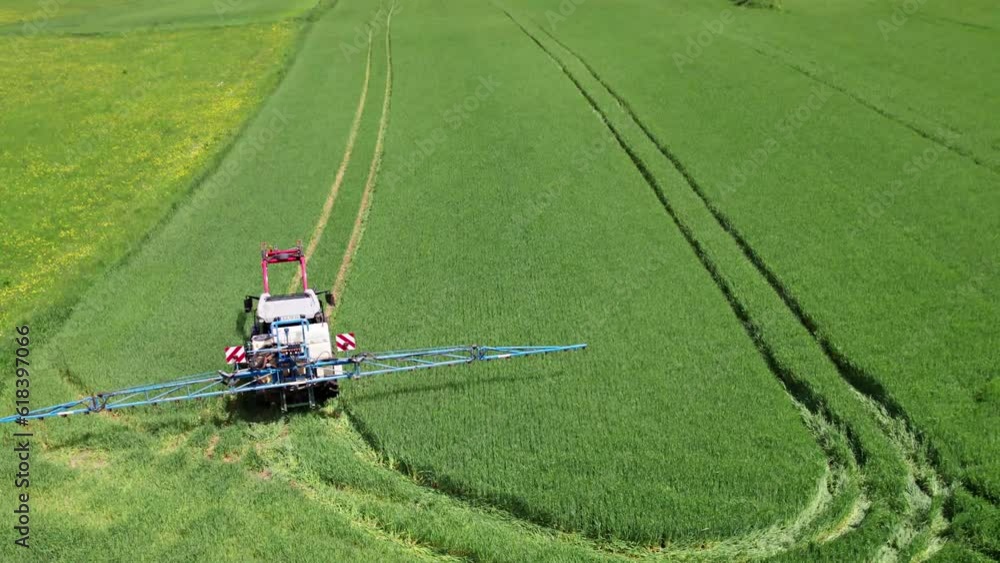 A tractor turning in a field leaving wheel tracks as it goes, aerial A tractor turning in a field leaving wheel tracks as it goes, aerial