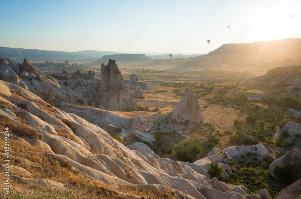 Fototapeta premium Sunrise in Cappadocia, The low morning sun illuminates the rock formations in Goreme National Park with soft golden light, Turkey travel