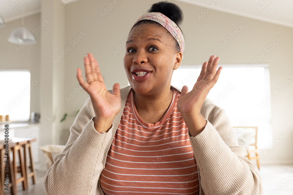 Happy african american woman sitting at table and having video call Happy african american woman sitting at table and having video call