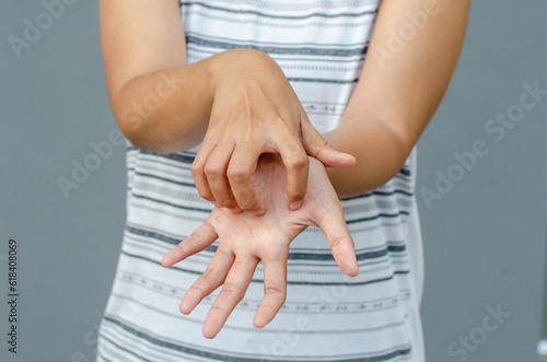 фотографія young asian woman scratching itch with hand on palm area, health care concept, d