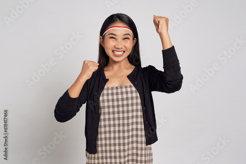 Excited young Asian woman celebrate Indonesia independence day on 17 August and show the spirit and soul of strong nationalism isolated over white background photo