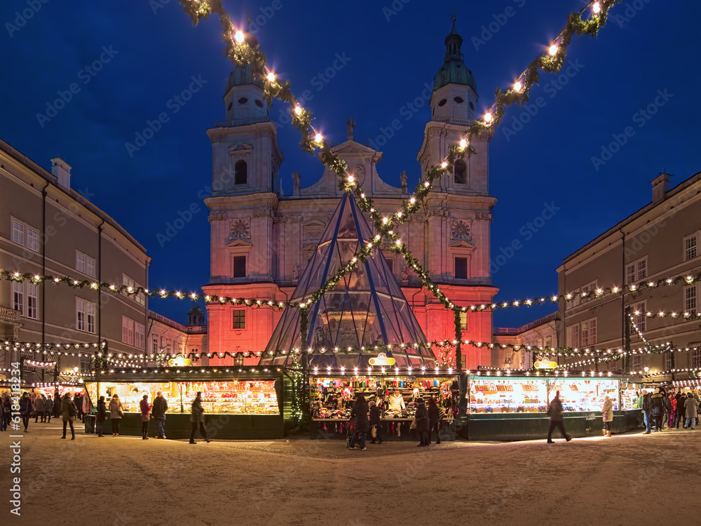 Salzburg, Austria. Christmas market at the Domplatz (Cathedral Square) in front of Salzburg Cathedral in twilight. The origins of the Salzburg Christmas market go back to the late 15th century.