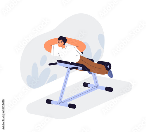 Man doing back extension on hyperextension bench in gym. Happy person trainin...